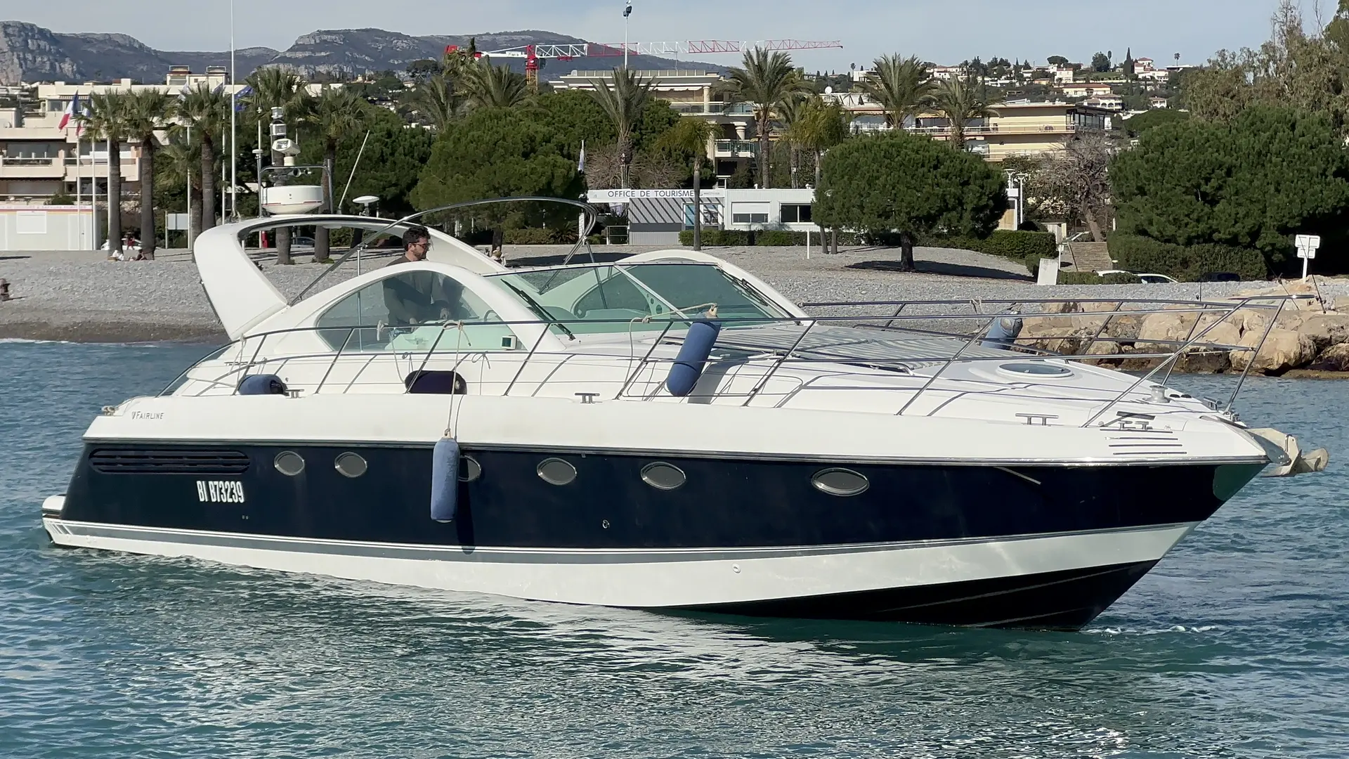 Fairline Targa 48 — Bateau à moteur blanc et bleu photographié de profil dans un port.