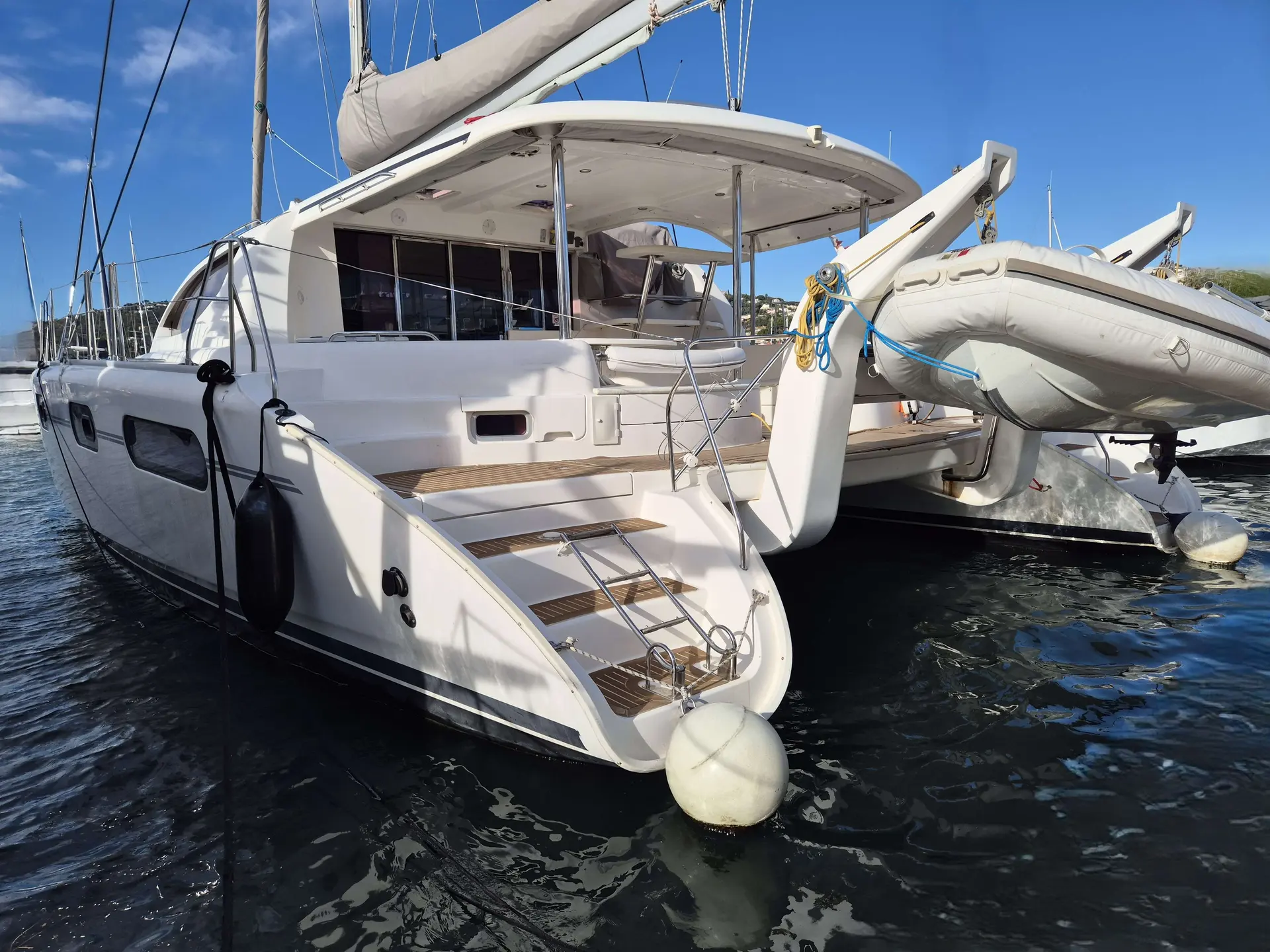 Leopard 46 — Catamaran blanc vu de trois quarts arrière, amarré au port avec son annexe.