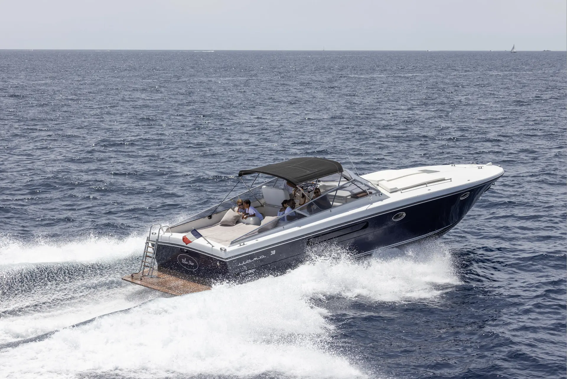 Itama 38 — Bateau à moteur blanc et bleu naviguant à vive allure sur la mer.