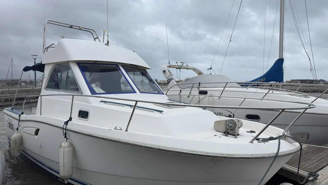 Beneteau Antares Serie 8 — Bateau à moteur blanc amarré au ponton, vu de trois quarts avant.