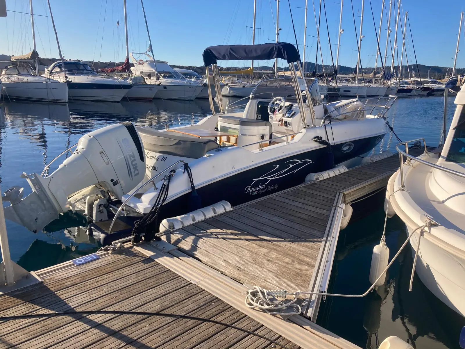 Aquabat Sport Infinity 750 — Bateau à moteur amarré au ponton, photographié de trois quarts arrière.