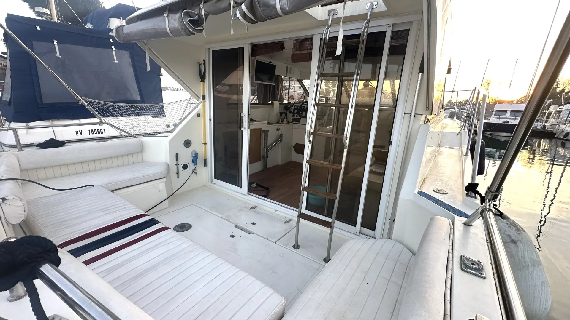Fairline Corniche 31 — Vue du cockpit arrière et de l'accès à la cabine d'un bateau amarré.