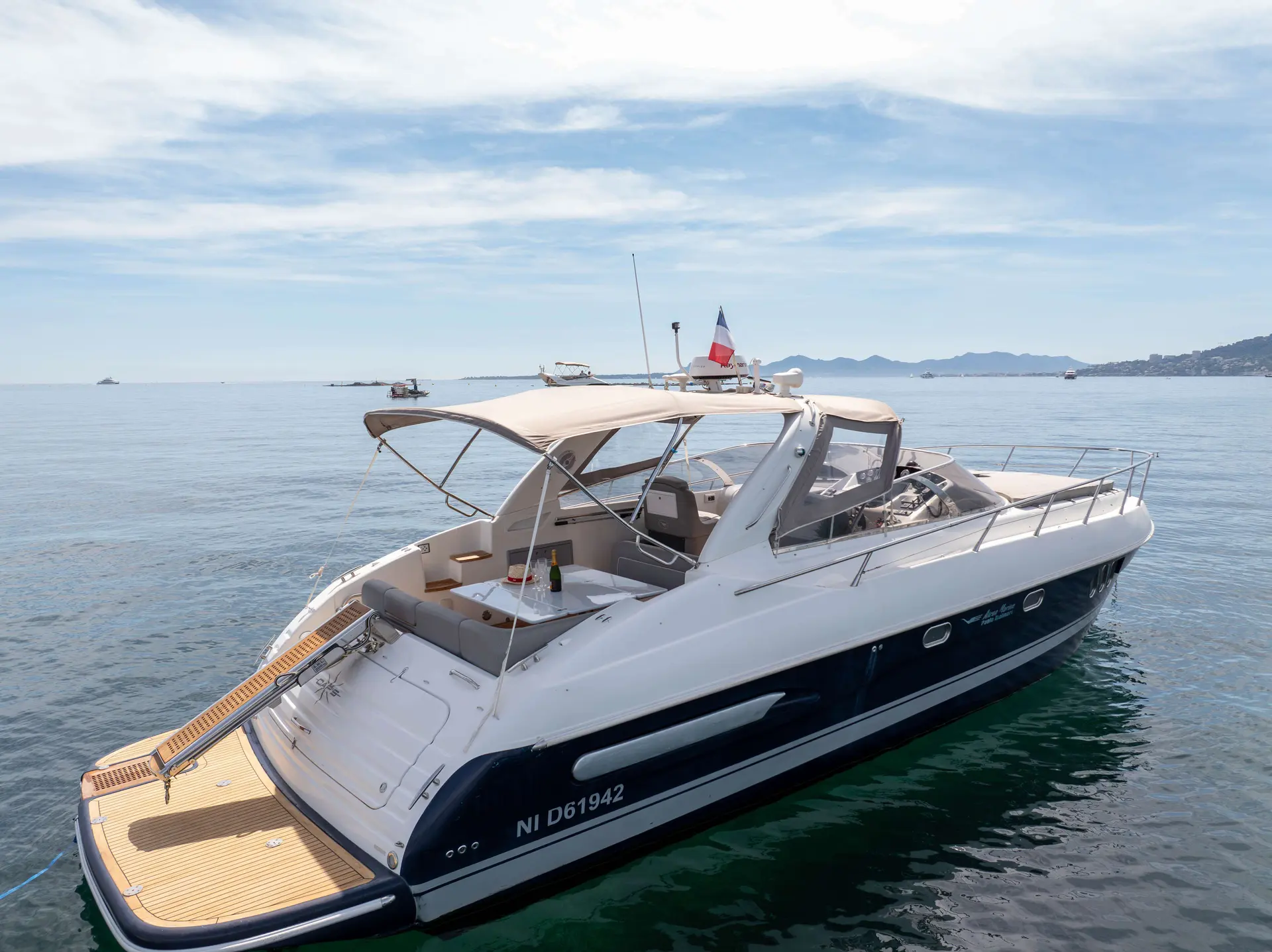 Airon Marine 425 — Bateau à moteur blanc et bleu photographié au mouillage, vu de trois quarts arrière.