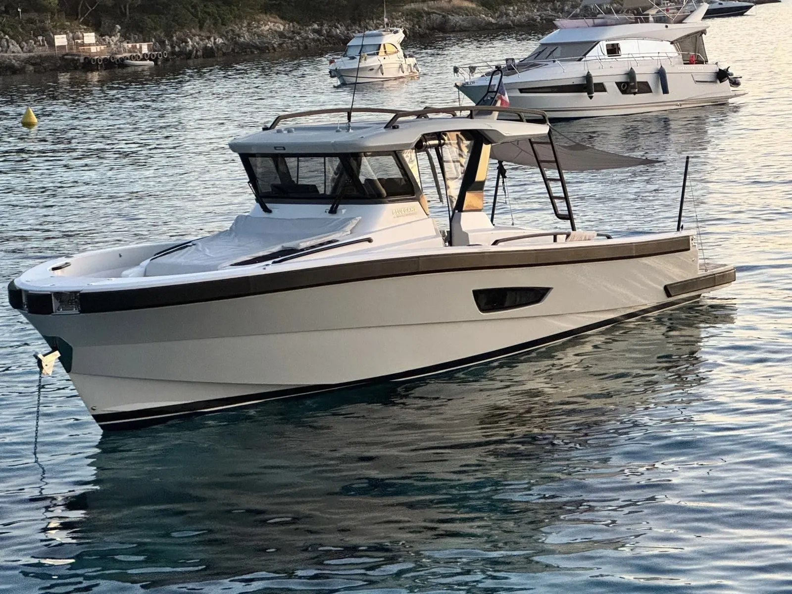 Bluegame 42 — Bateau à moteur blanc vu de trois quarts dans une baie, au mouillage.