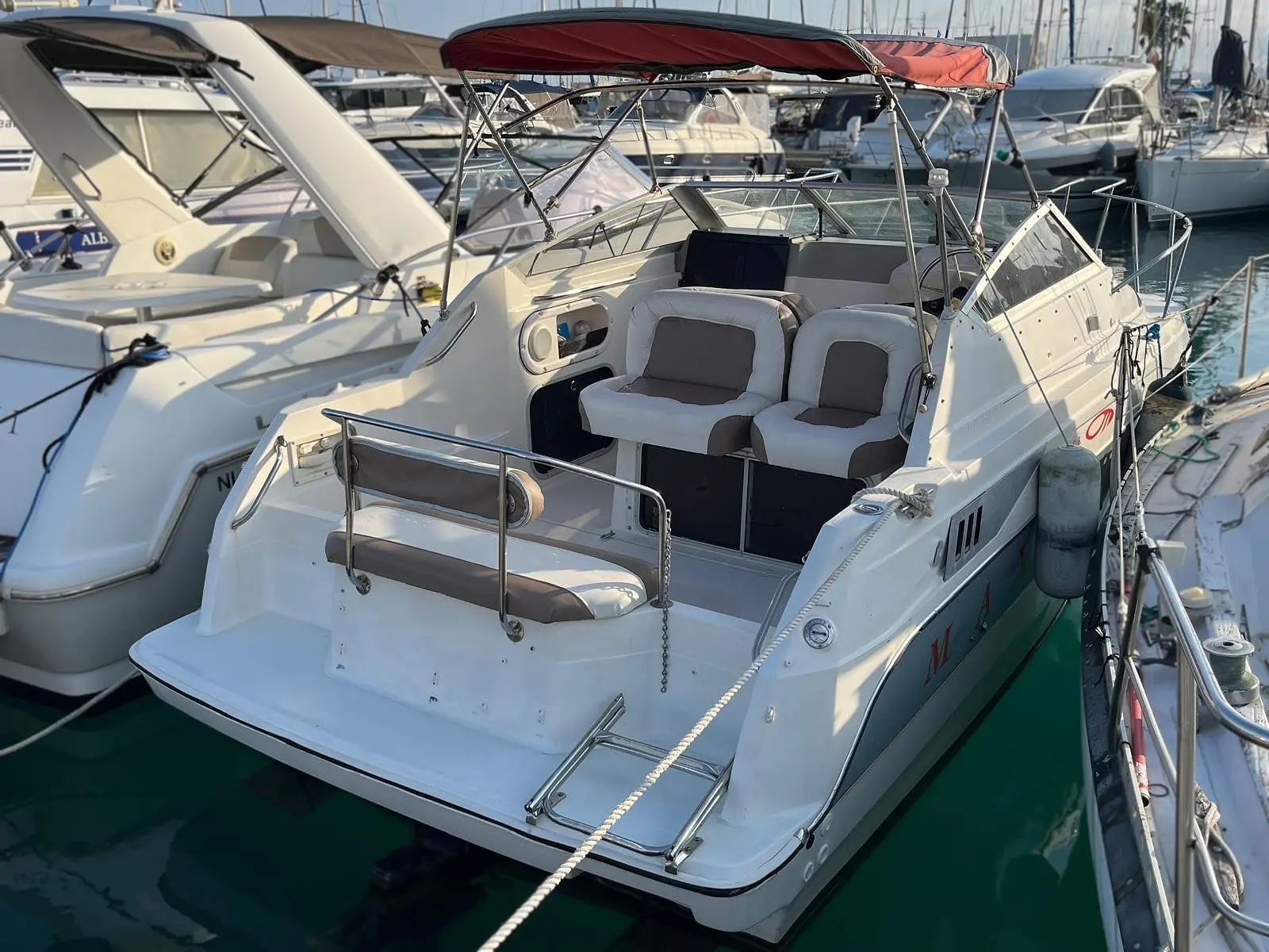Maxum 2355 SCR — Bateau à moteur blanc amarré, vu de trois quarts arrière dans une marina.