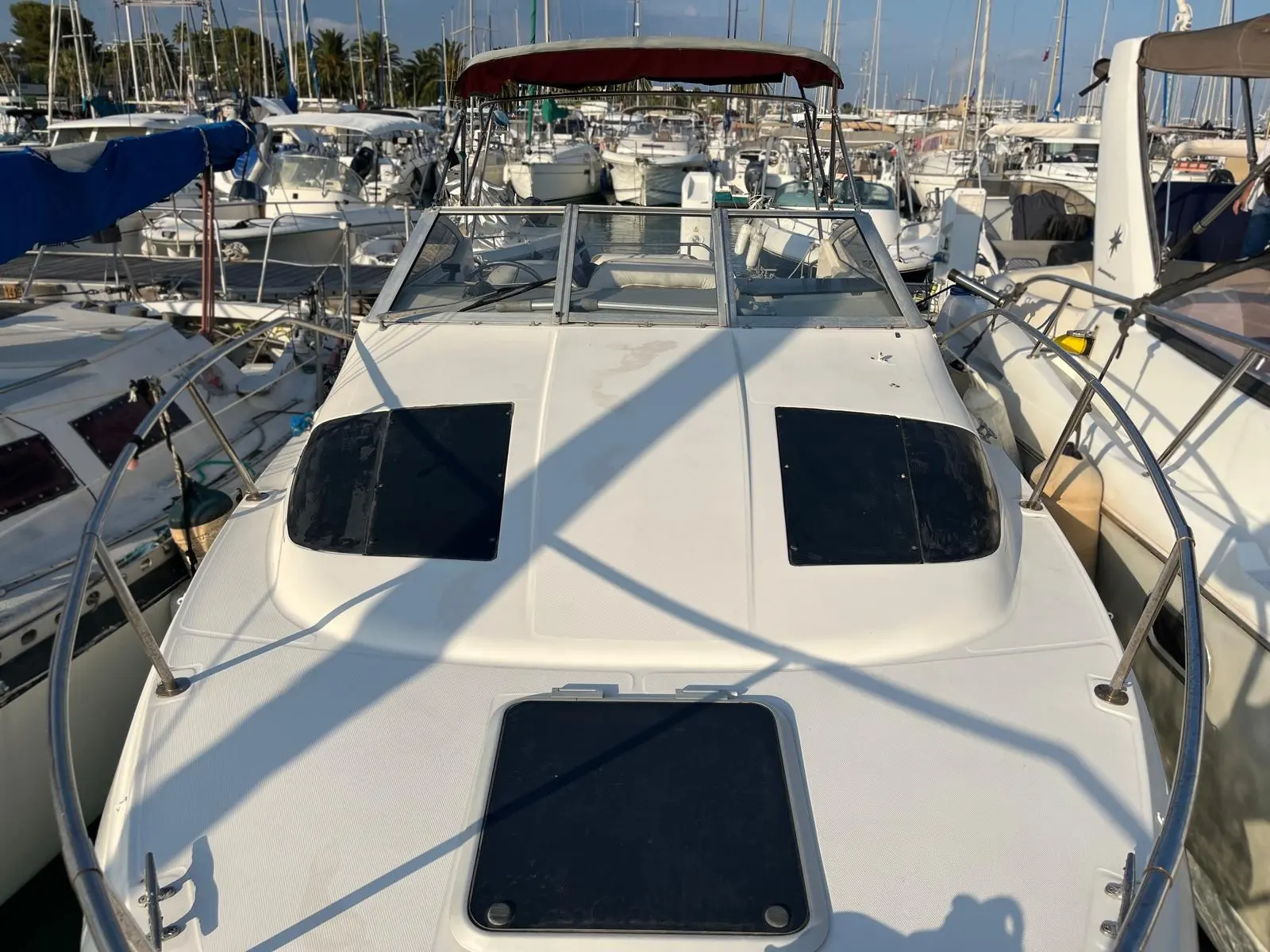 Maxum 2355 SCR — Vue avant d’un bateau à moteur amarré dans une marina.