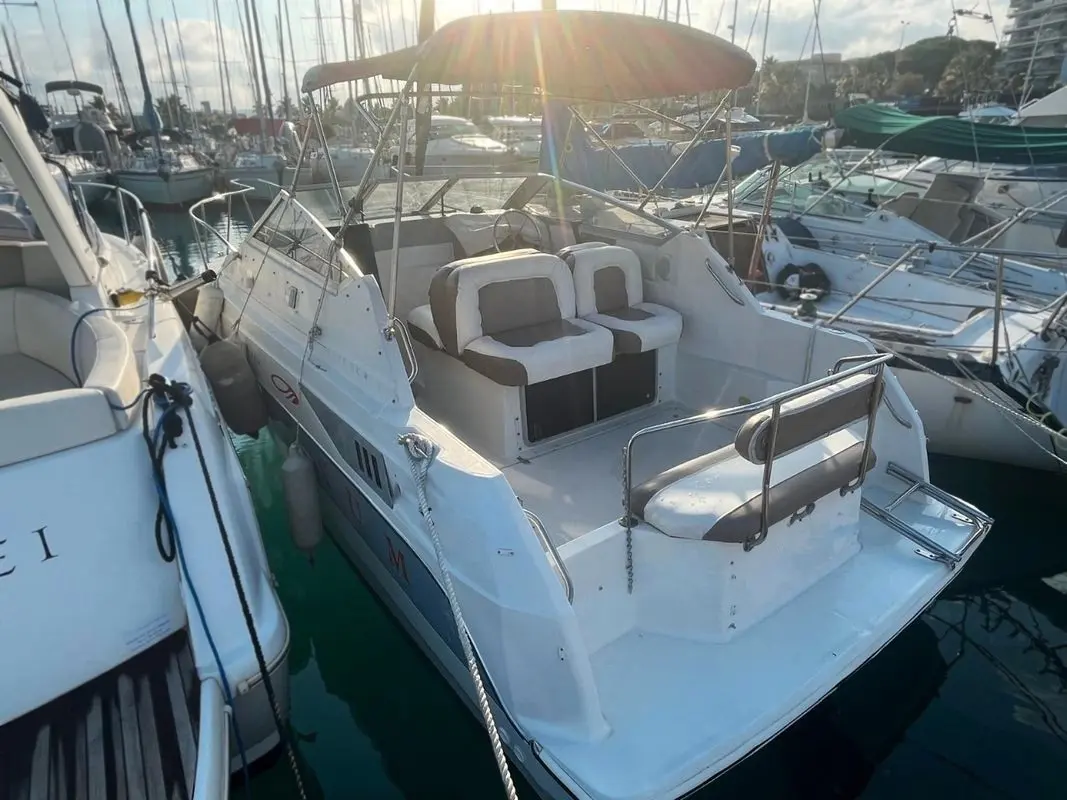 Maxum 2355 SCR — Vue arrière trois quarts d’un bateau à moteur amarré dans une marina.
