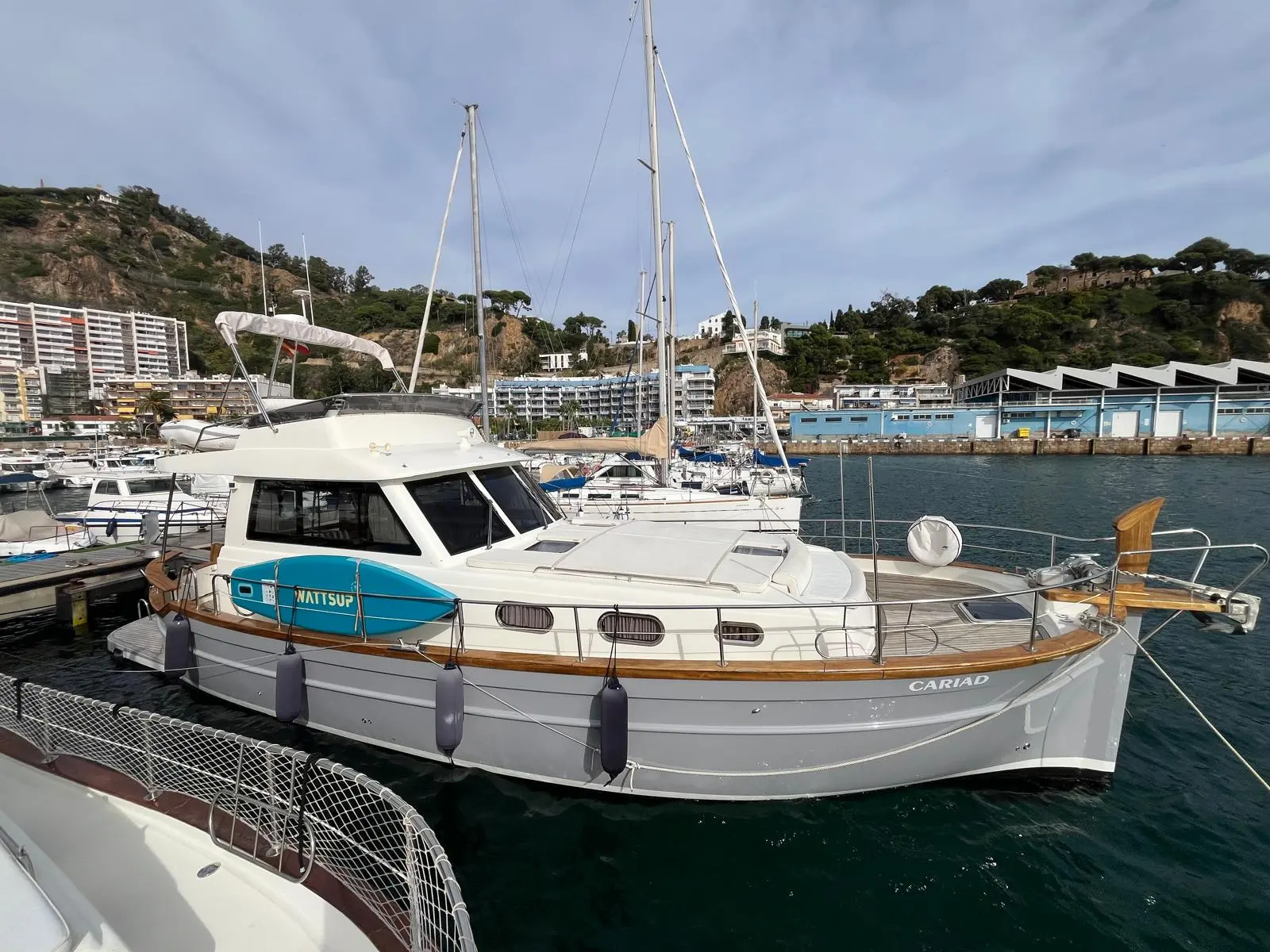 Menorquin 145 — Bateau à moteur blanc photographié de trois quarts dans une marina.