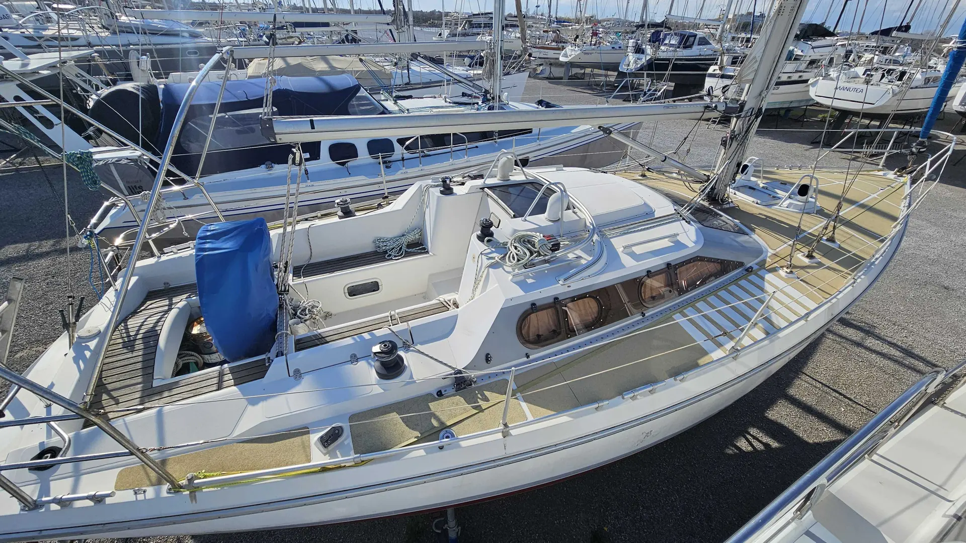 Etap 38 I — Voilier blanc vu de trois quarts à quai, entouré d'autres bateaux.