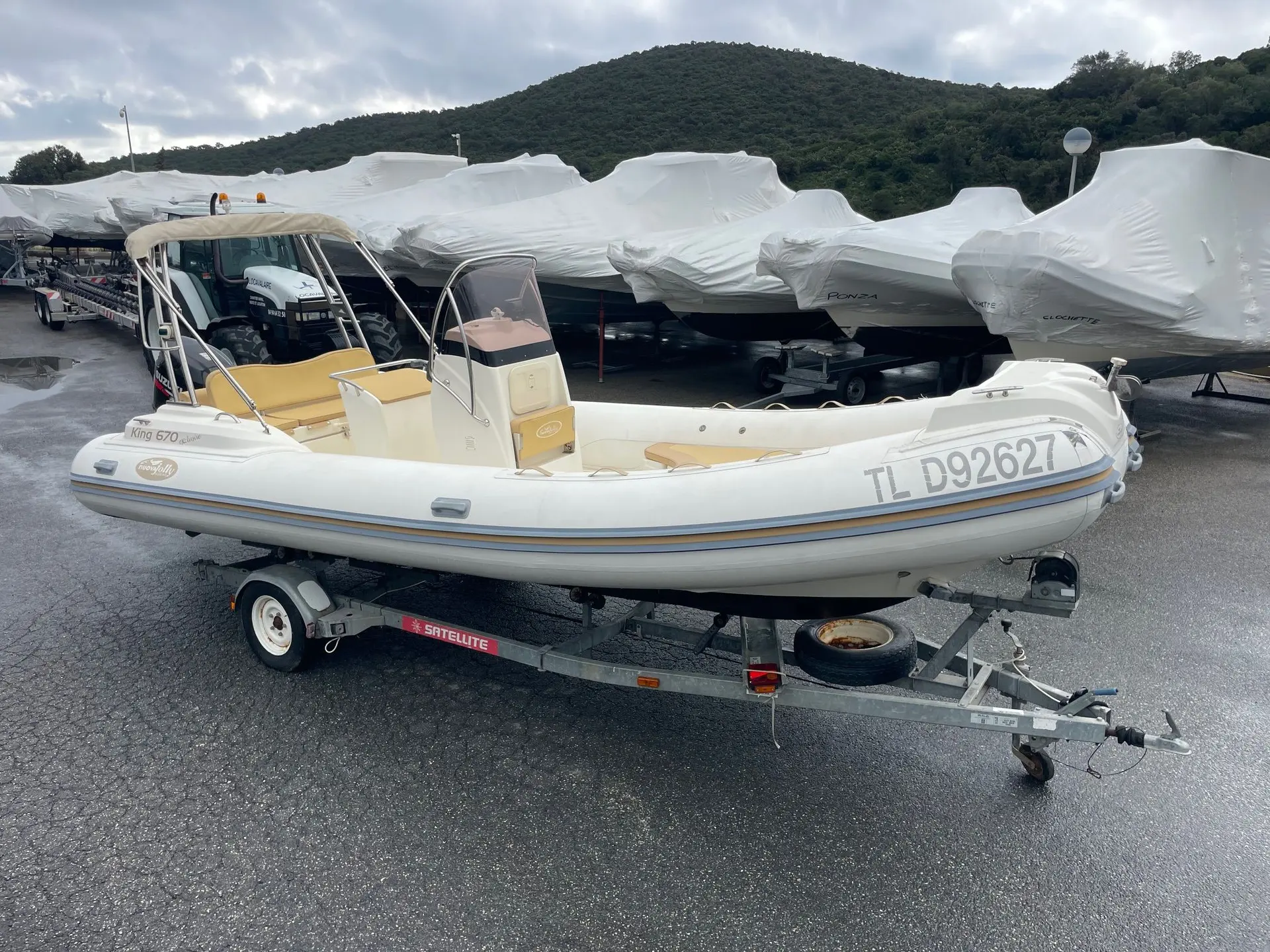 Nuova Jolly King 670 — Bateau semi-rigide blanc sur remorque, photographié de trois quarts.