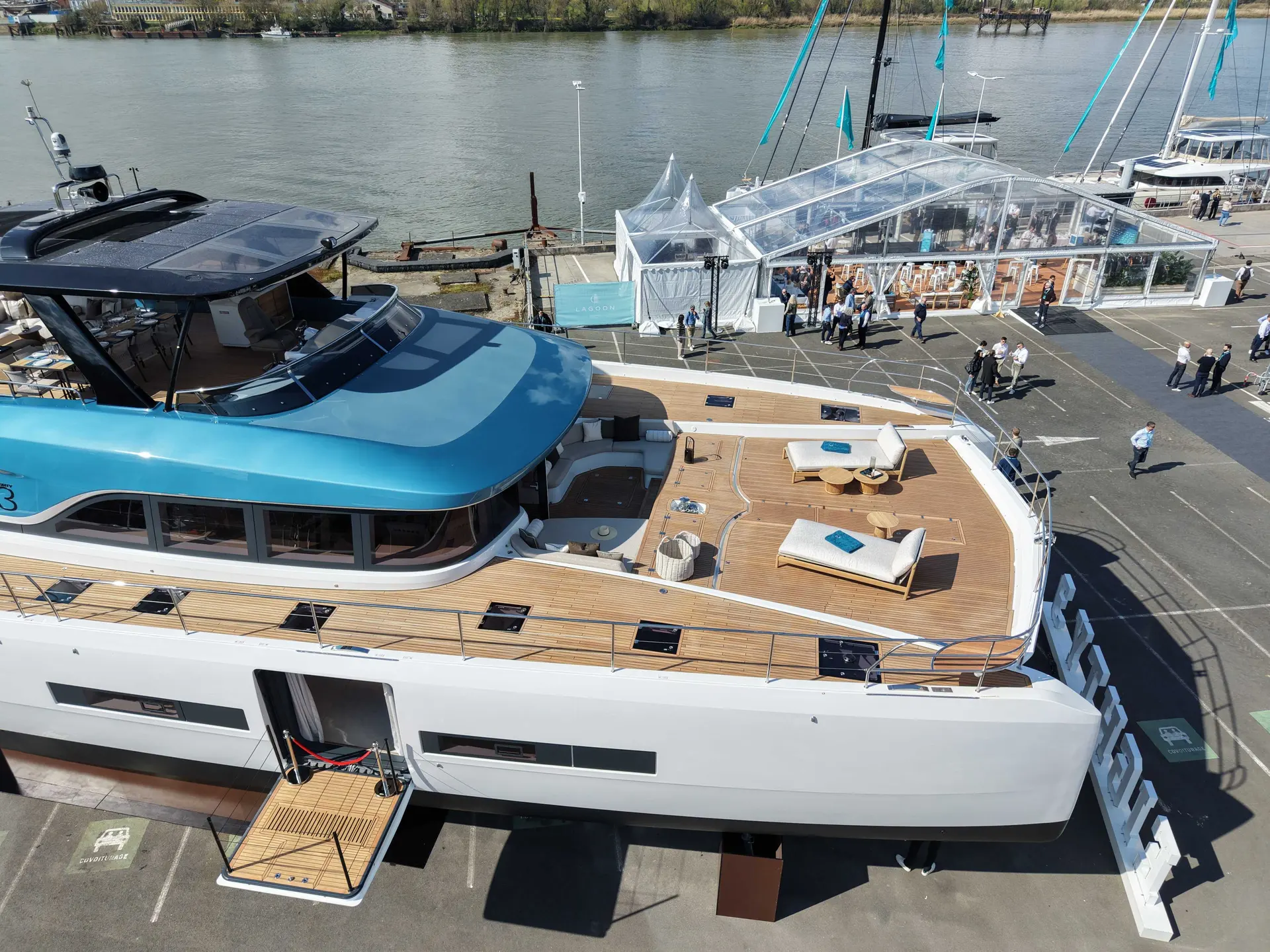 Lagoon Eighty 3 — Vue en plongée d’un yacht exposé, avec pont avant aménagé et salon extérieur.