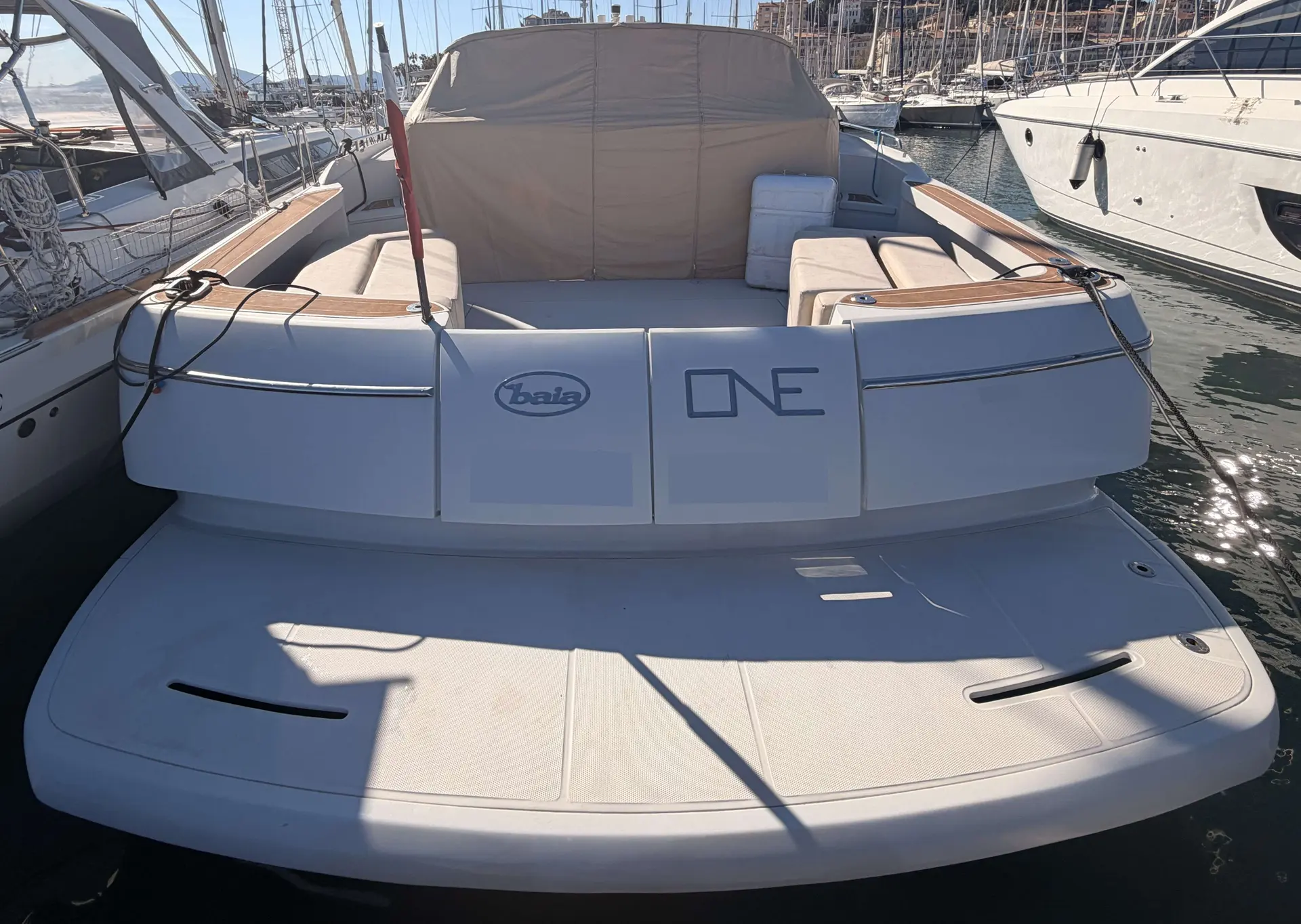 Baia One 43 — Bateau à moteur vu de l’arrière, avec cockpit et plateforme arrière dans un port.