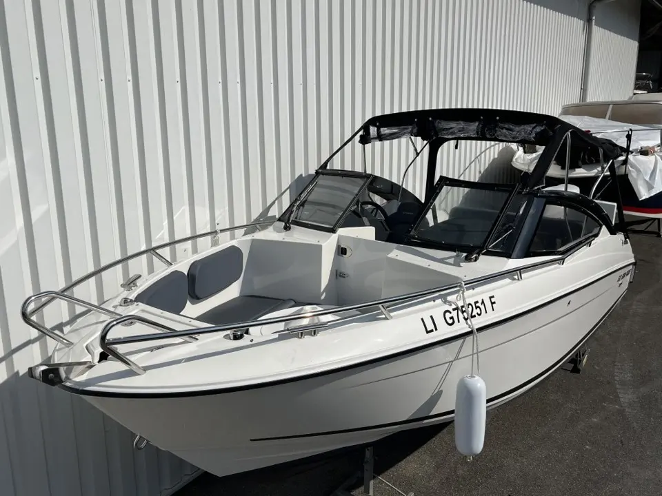 Parker 630 Bow Rider — Bateau blanc vu de trois quarts, avec pare-brise, arceau noir et garde-corps.