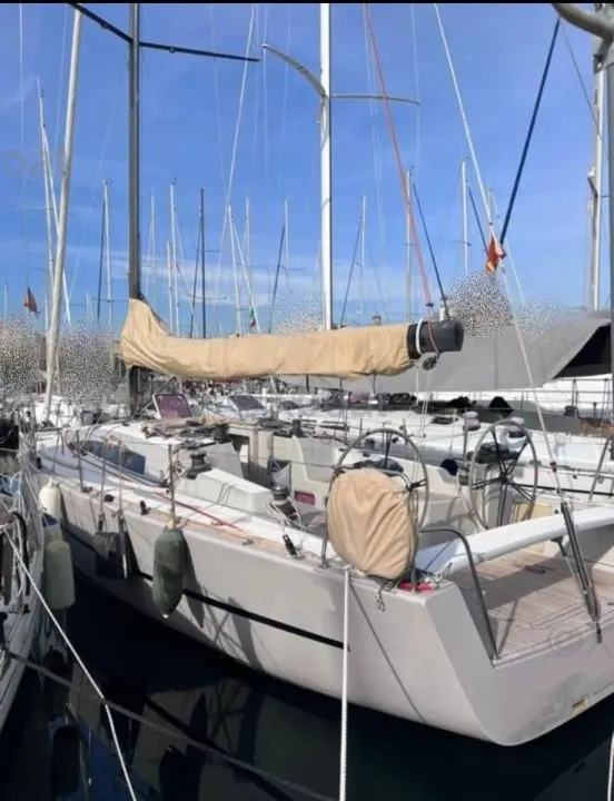 Sly Yachts Sly 42 — Voilier blanc amarré dans une marina, vu de trois quarts arrière.