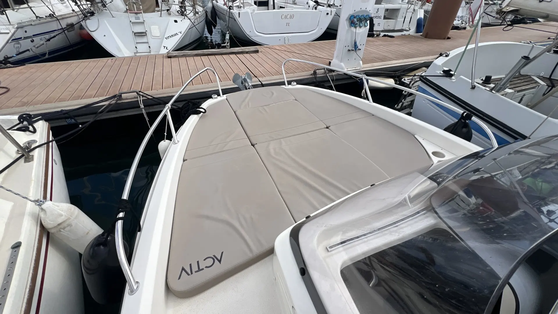 Quicksilver 605 Sundeck — Vue plongeante du pont avant d’un bateau amarré dans un port.