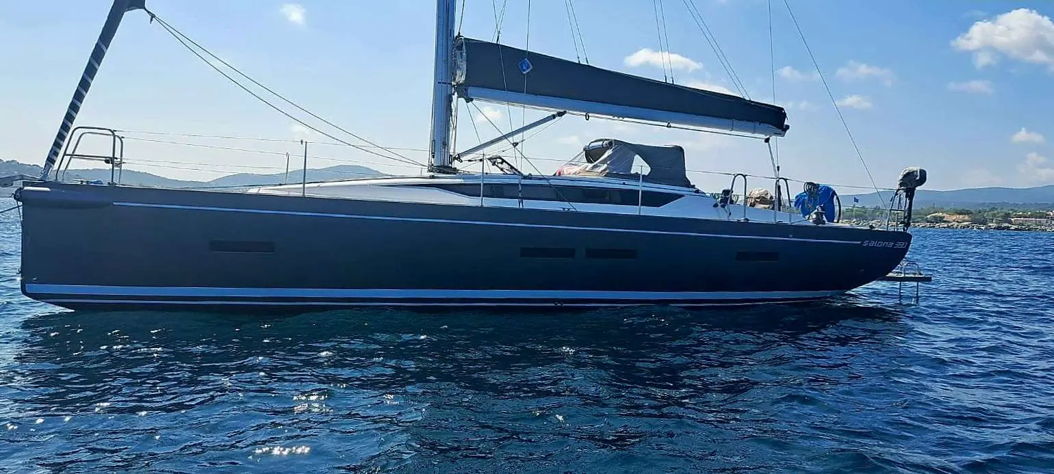 Salona 380 — Voilier monocoque vu de profil, amarré sur une mer calme sous un ciel dégagé.