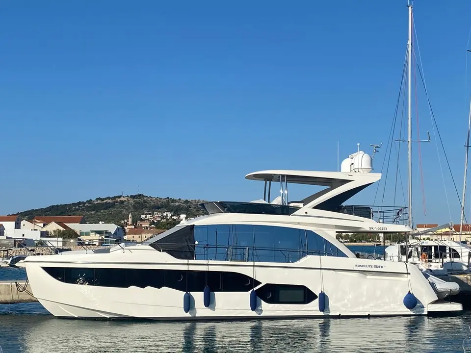 Absolute 58 Fly — Vue de profil d’un yacht à moteur blanc amarré dans un port.