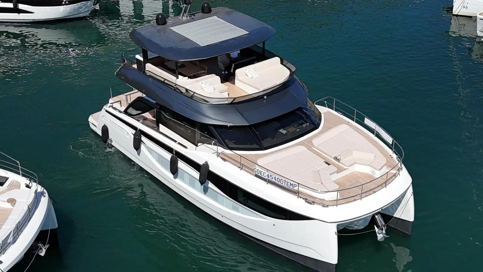 Prestige Yachts M7 — Vue en plongée d’un yacht blanc amarré, avec pont avant et salon supérieur visibles.