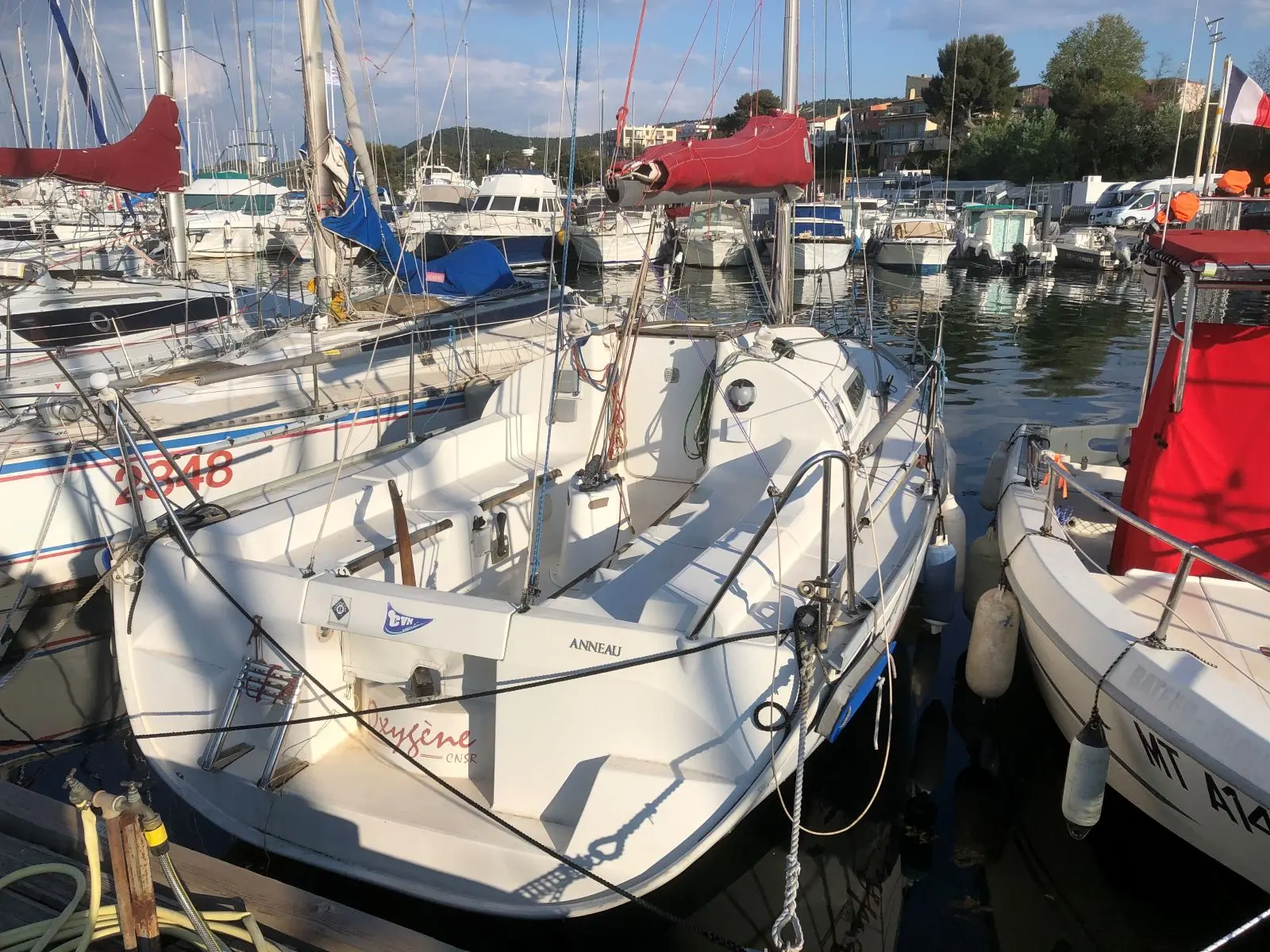 Jeanneau Sun Fast 26 — Voilier blanc amarré dans une marina, entouré d'autres bateaux.