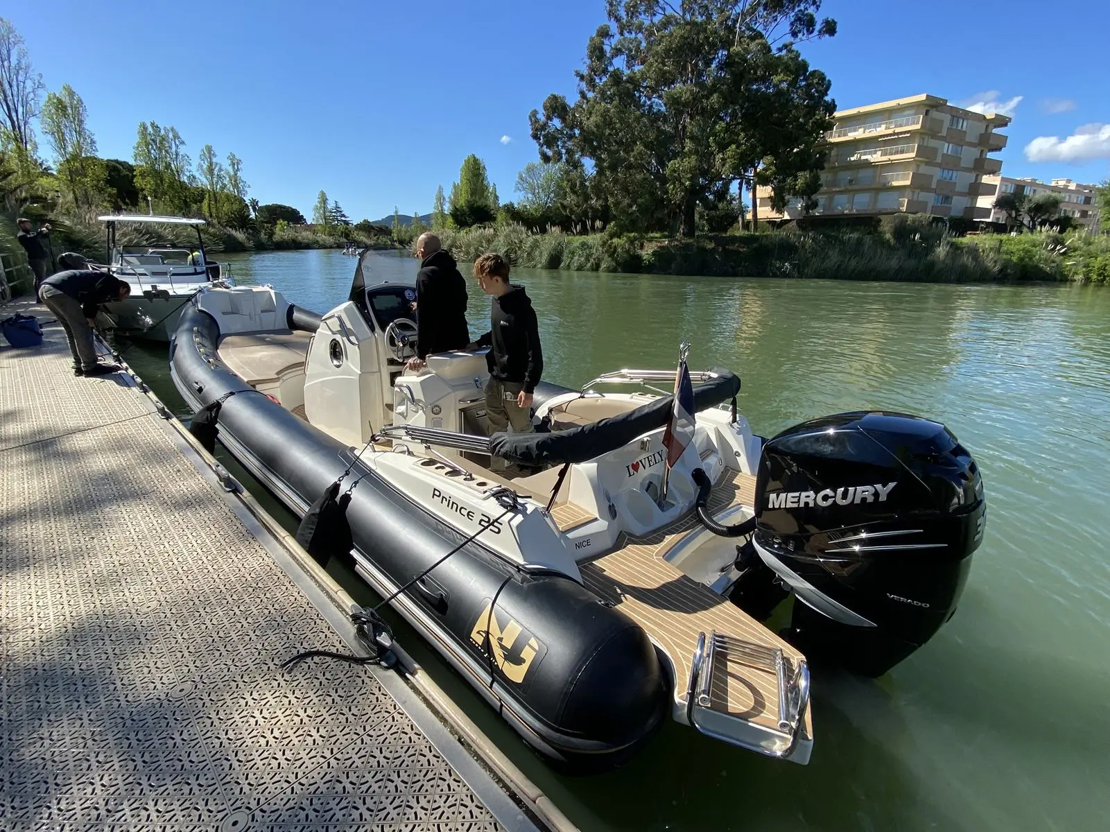 Nuova Jolly Prince 25 — Semi-rigide amarré à un ponton, avec moteur hors-bord et deux personnes à bord.