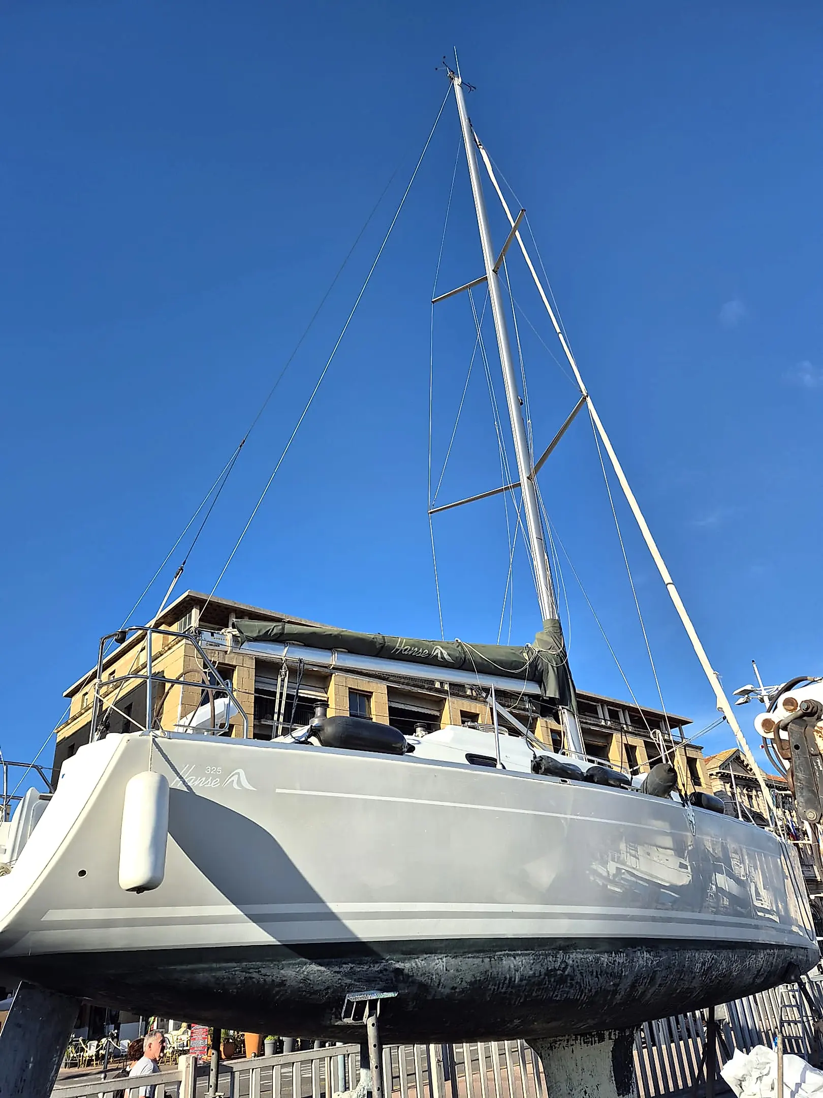 Hanse 325 — Voilier photographié à terre, vu depuis l’arrière sous un ciel dégagé.