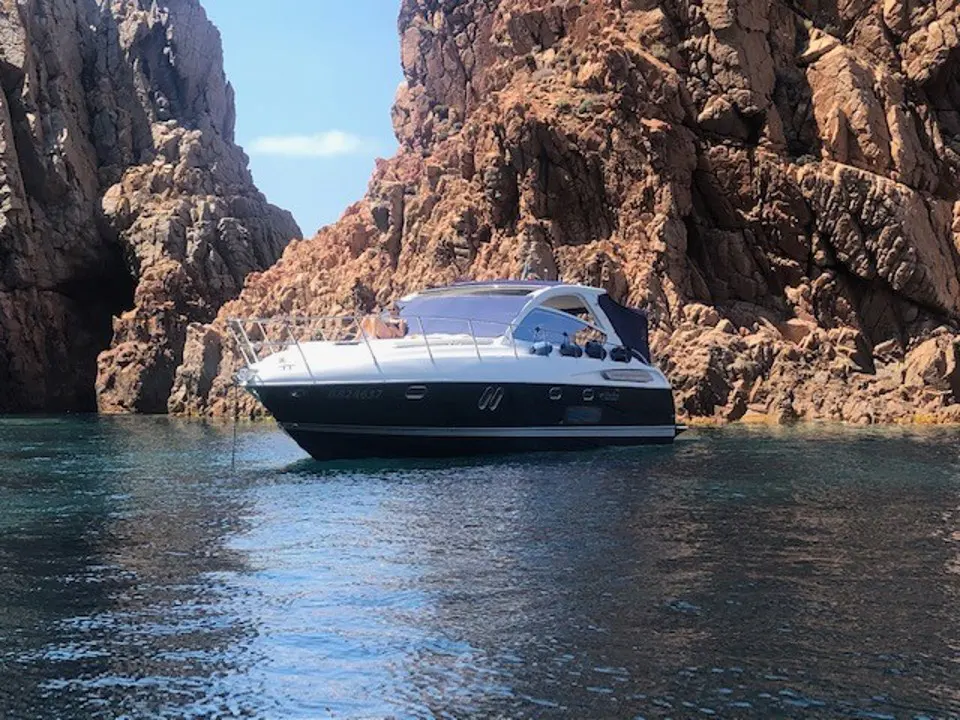 Airon Marine 4100 T-Top — Bateau à moteur vu de profil dans une crique rocheuse.