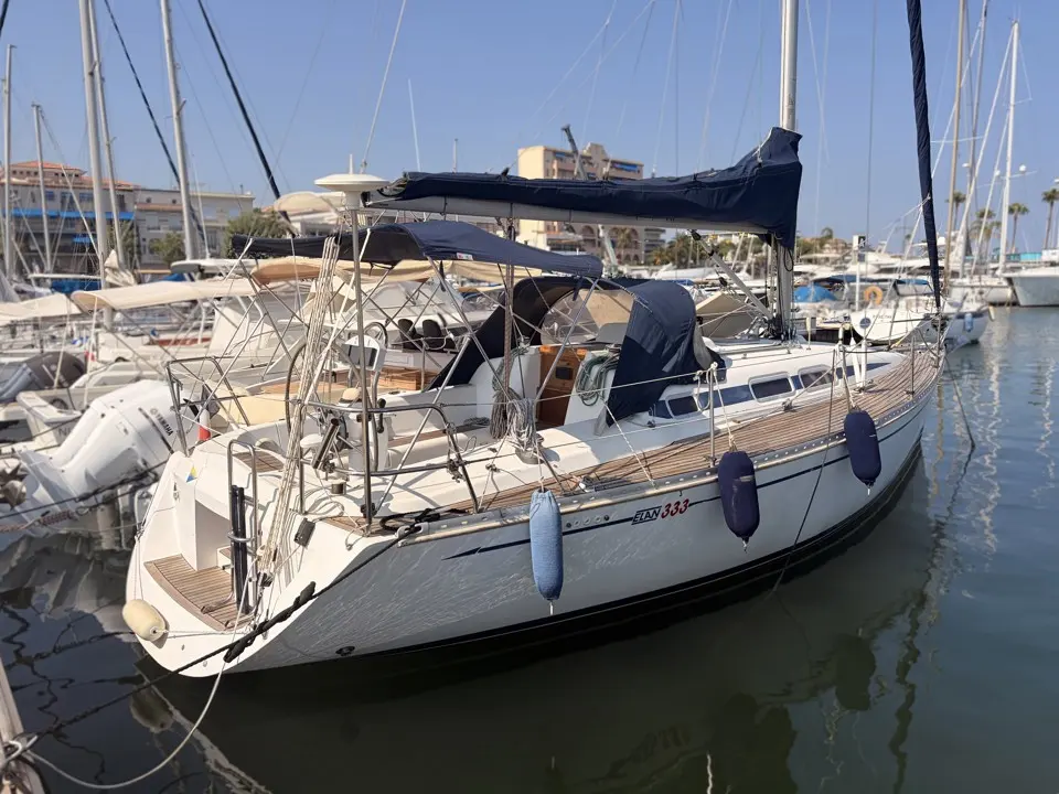 Elan 333 — Voilier blanc amarré, photographié de trois quarts dans une marina.