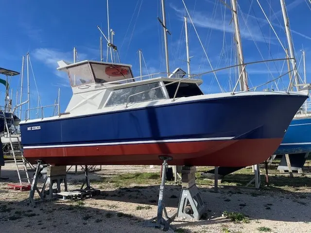 Gibert Marine Gib Sea 334 — Bateau à moteur bleu et rouge posé sur bers dans un chantier nautique.