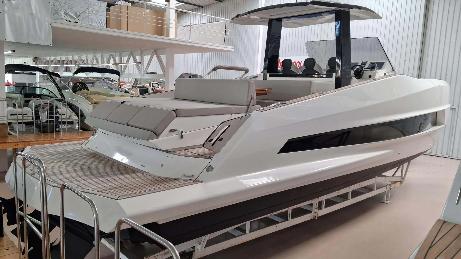Astondoa 377 Coupe — Bateau à moteur blanc présenté en vue trois quarts dans un showroom.