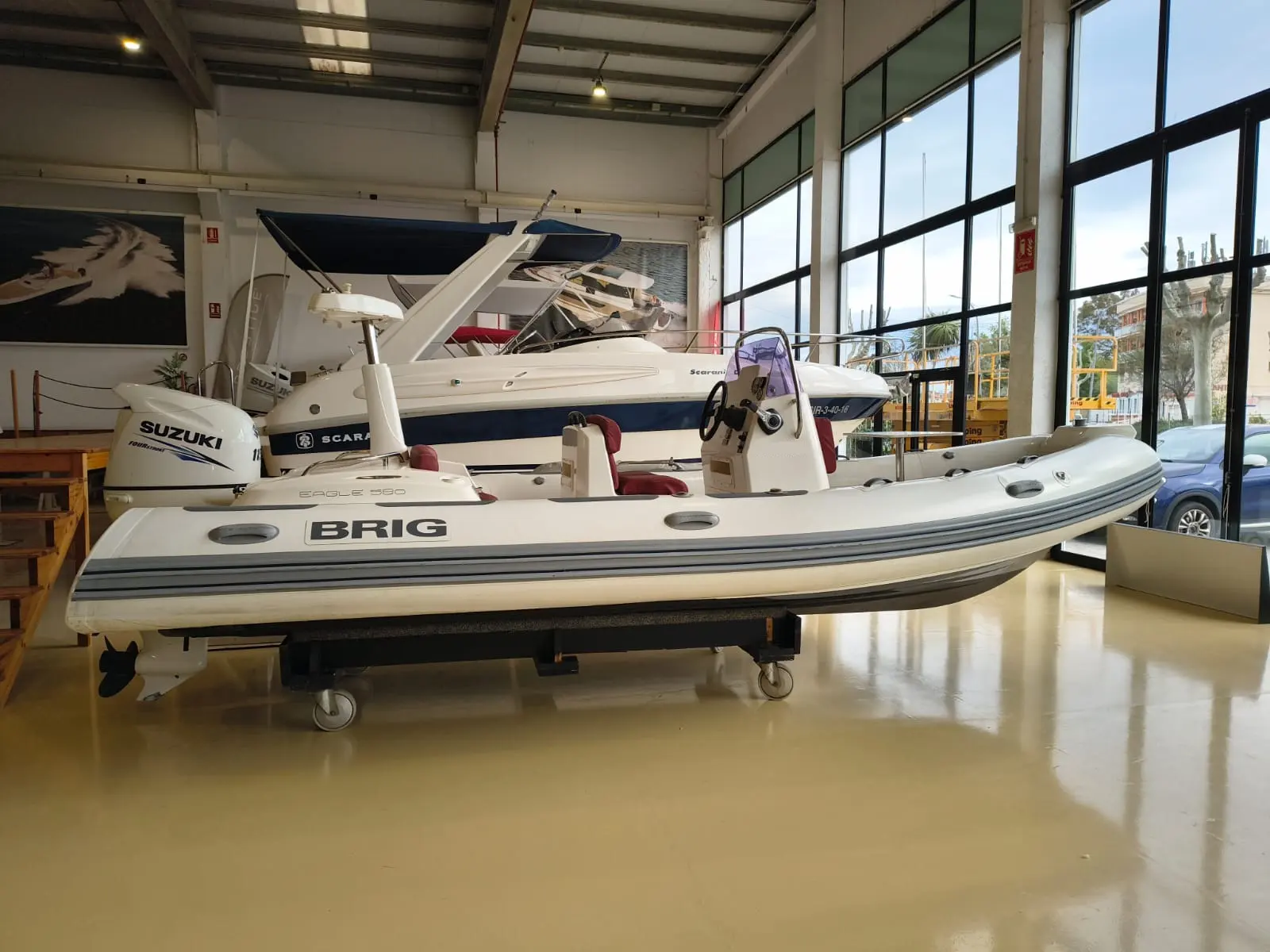 Brig Eagle 580 — Semi-rigide BRIG blanc présenté en intérieur, vu de profil avec moteur hors-bord.
