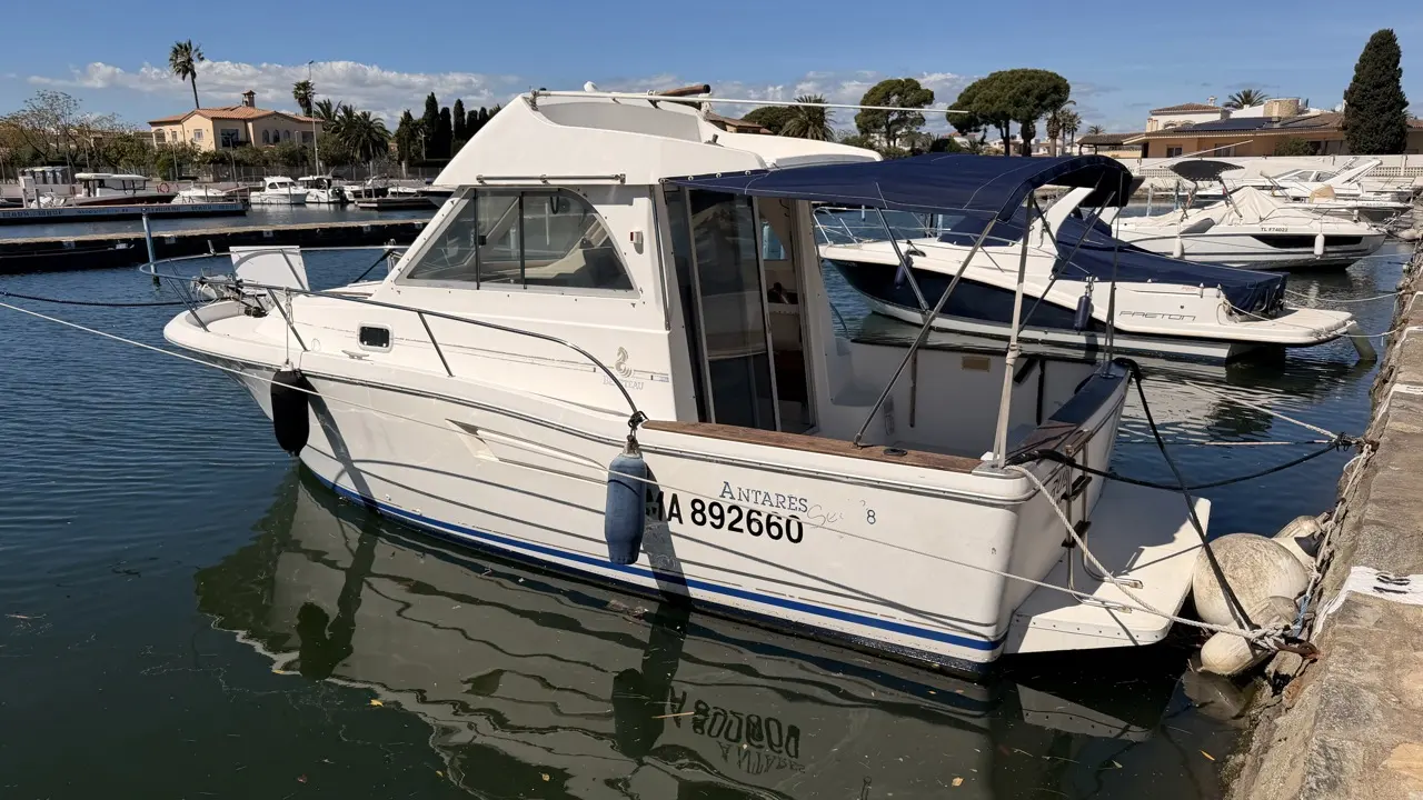 Beneteau Antares Serie 8 — Bateau à cabine amarré dans un port de plaisance, vu de trois quarts arrière.