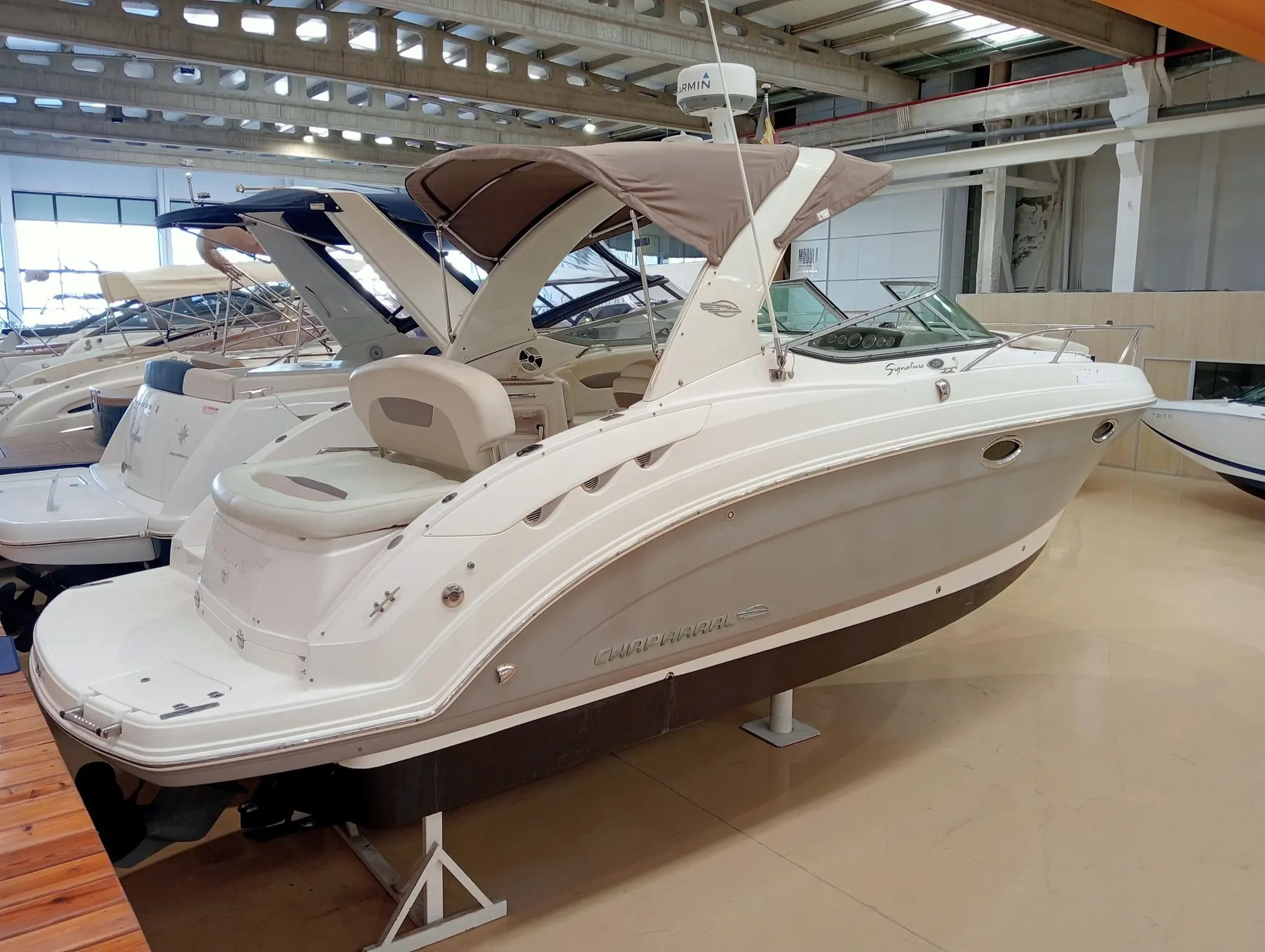 Chaparral Signature 250 — Bateau blanc exposé en intérieur, vu de trois quarts arrière tribord.