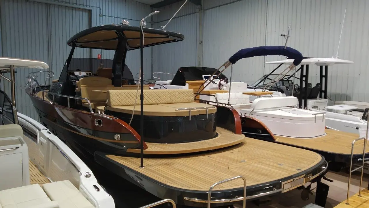 Positano 32 Open — Vue arrière trois-quarts d’un bateau exposé dans un hangar avec d’autres embarcations.