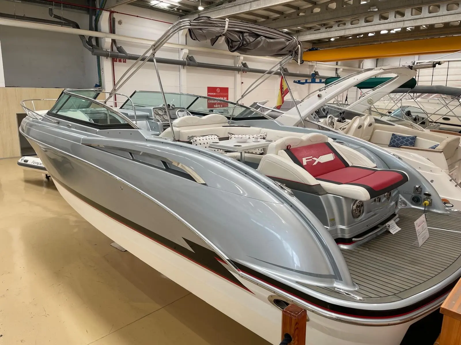 Formula 310 Sun Sport — Bateau à moteur gris et blanc exposé dans un hangar, vu de trois quarts avant.