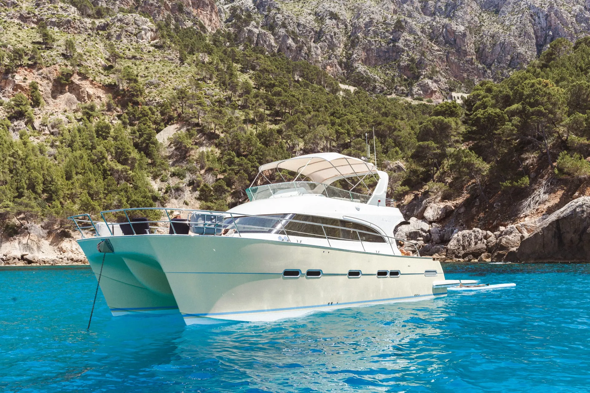 Galatzo K One 45 — Bateau à moteur blanc vu de trois quarts dans une crique aux eaux turquoise.