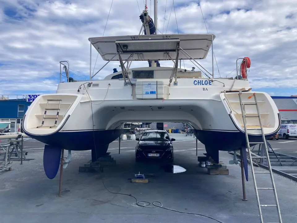 Fountaine Pajot Tobago 35 — Vue arrière d’un catamaran blanc posé à terre dans un chantier naval.
