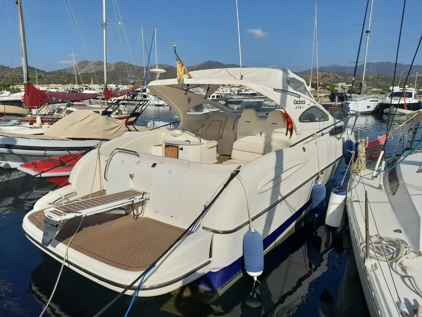 Gobbi 375 SC — Bateau à moteur Gobbi amarré dans une marina, vu de trois quarts arrière.