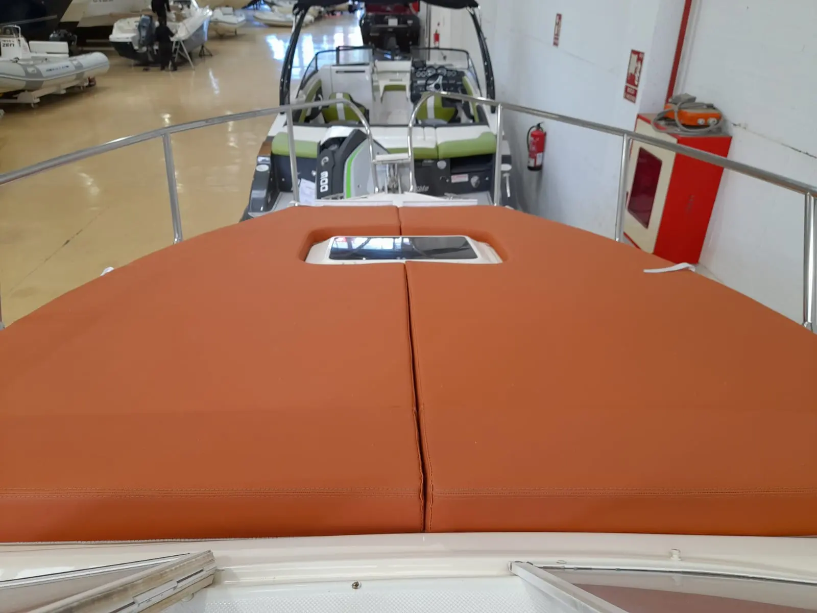 Coverline 710 Cabin — Vue du bain de soleil avant et du cockpit d’un bateau exposé en intérieur.