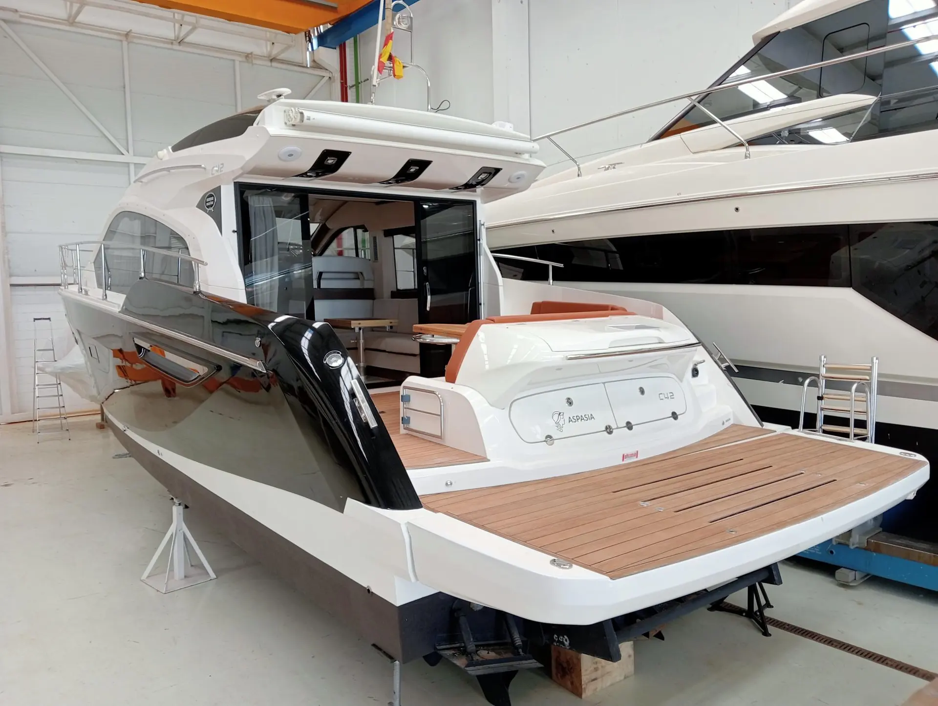 Sessa Marine C42 — Bateau à moteur vu de trois quarts arrière dans un hangar, avec cockpit ouvert.