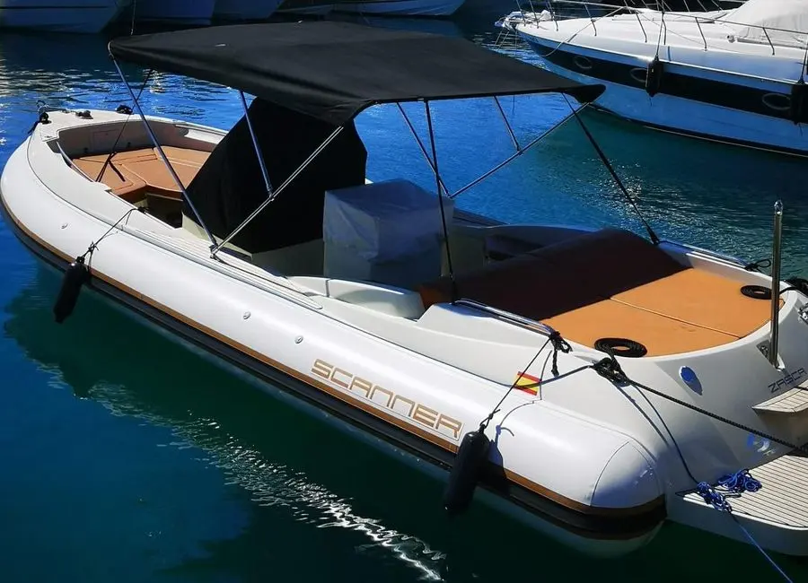 Scanner Envy 860 Hb — Bateau à moteur blanc amarré dans une marina, vu de trois quarts.
