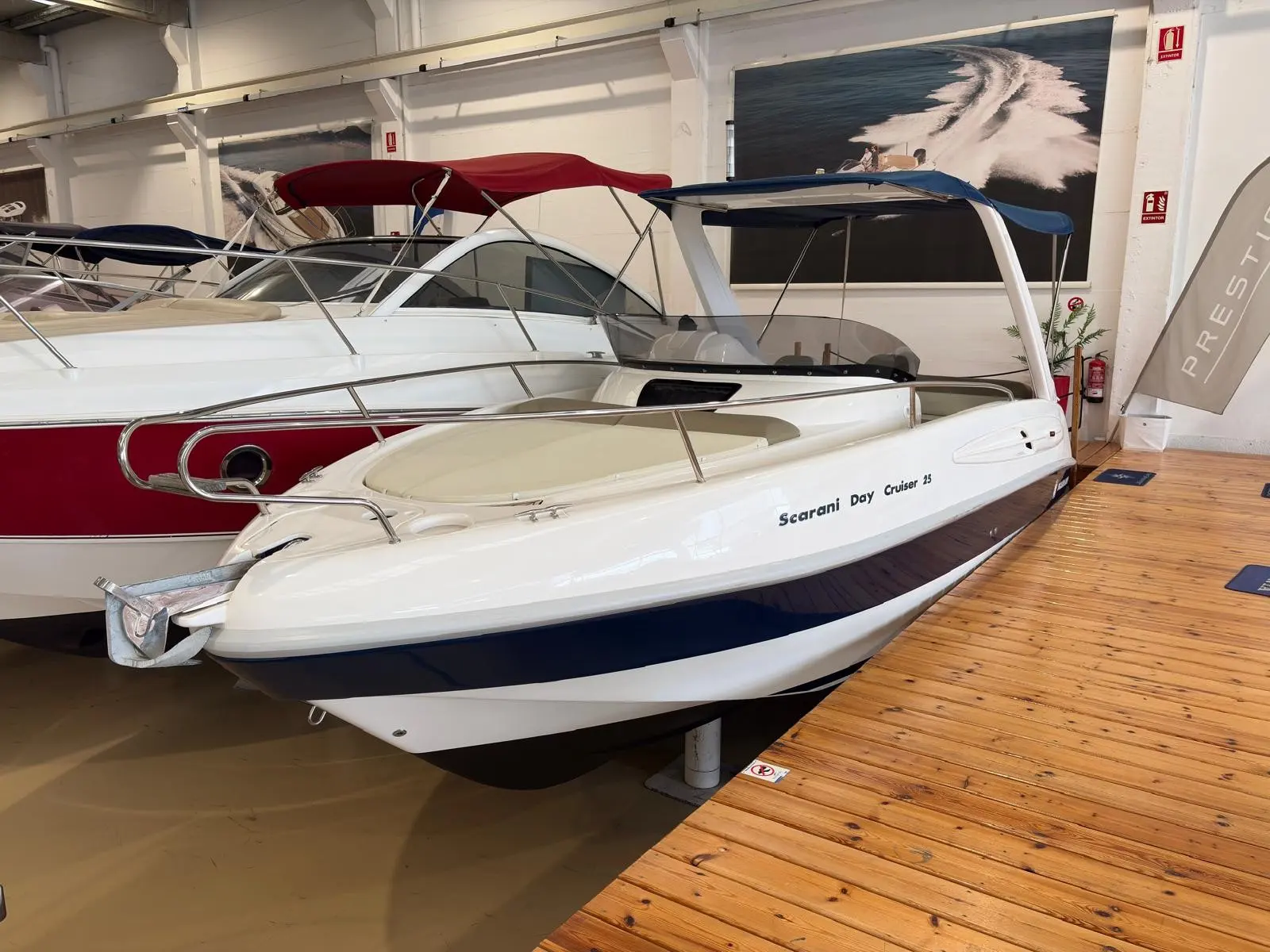 Scarani 25 Day Cruiser — Bateau de plaisance blanc présenté en vue trois quarts dans un showroom.
