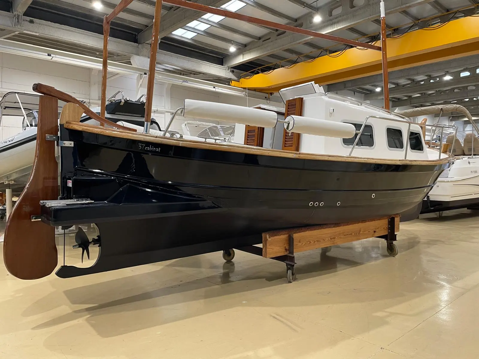 Tiburon 37 Cabinado — Bateau à cabine photographié sur berceau dans un hangar.