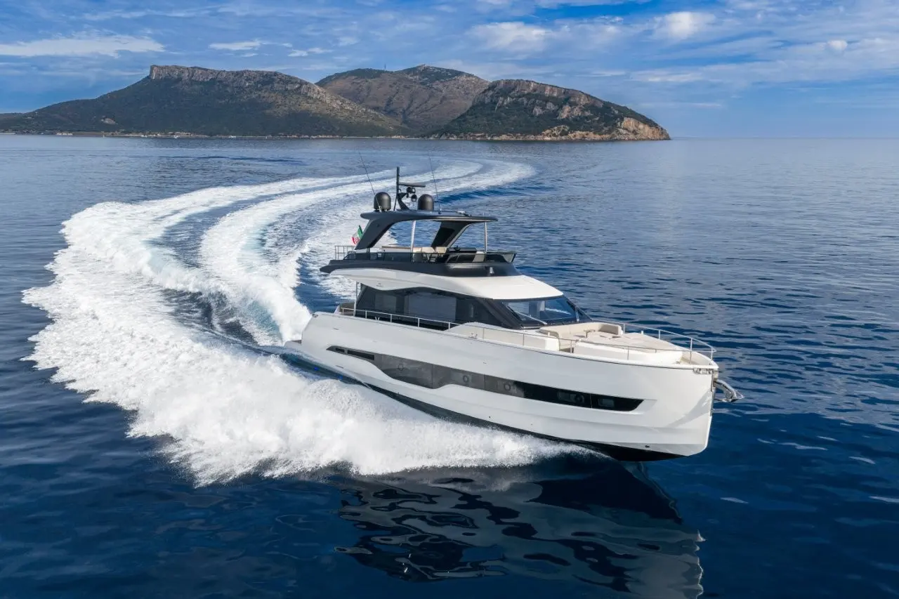 Cranchi Sessantadue  62 — Bateau à moteur blanc naviguant à vive allure devant une côte montagneuse.
