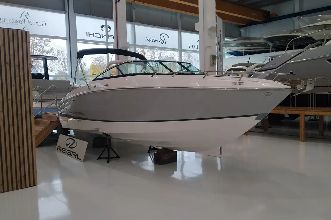 Regal LS4C — Bateau blanc exposé à sec dans un showroom nautique, vu de trois quarts avant.
