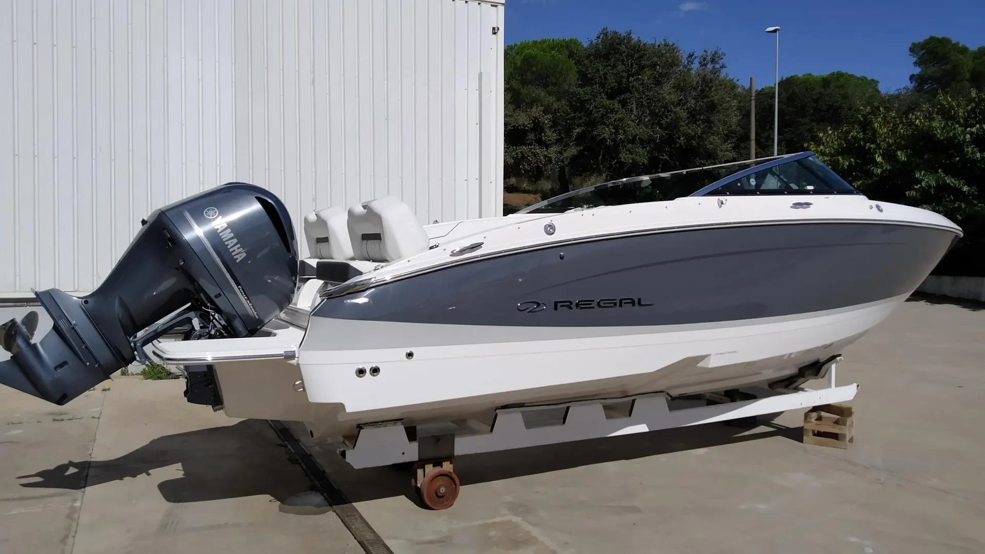 Regal LX4 — Bateau à moteur blanc et gris présenté sur remorque, vu de trois quarts côté tribord.