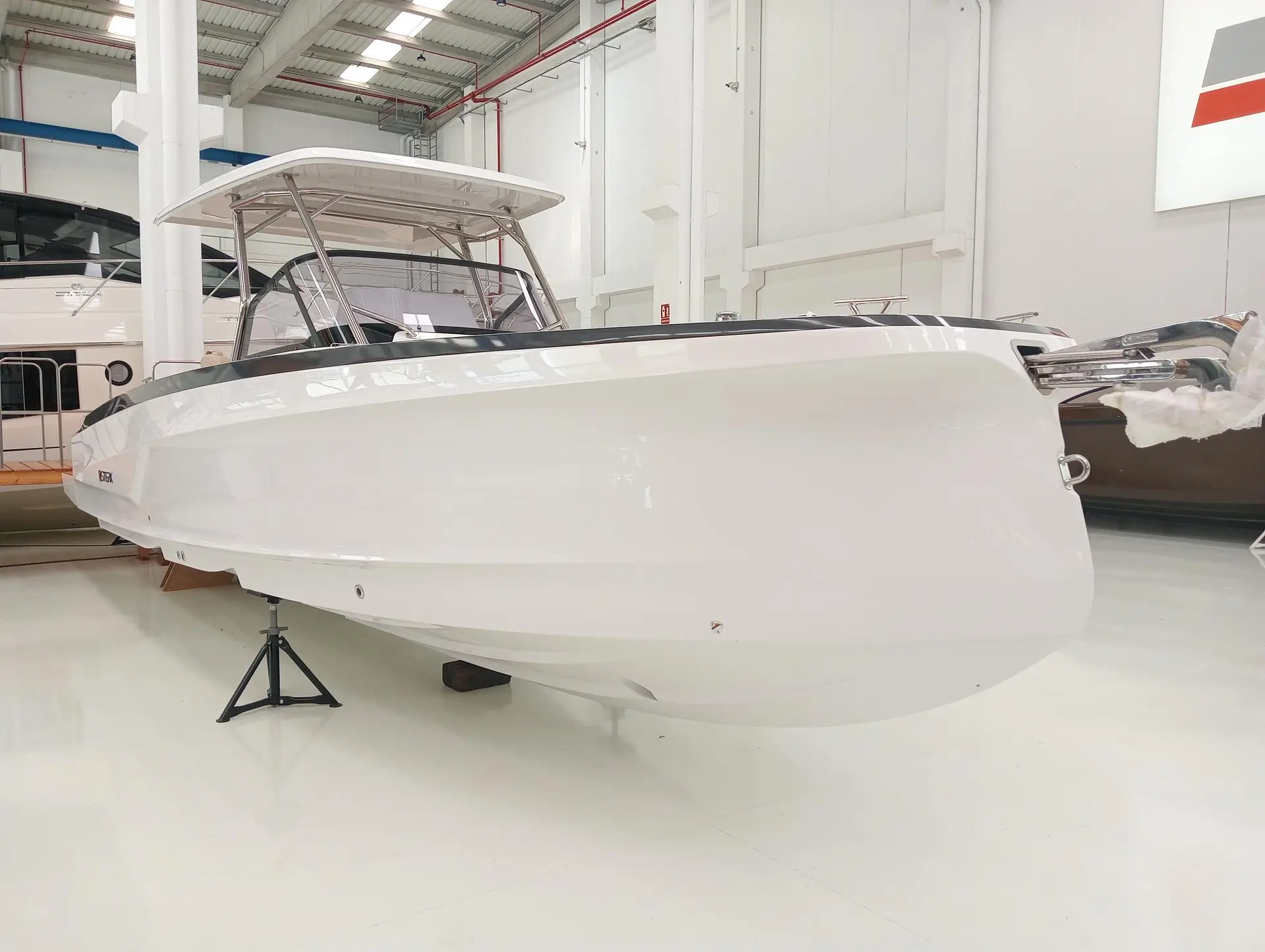 Sterk 31 WB Sport — Bateau blanc exposé sur berceau dans un hall intérieur.