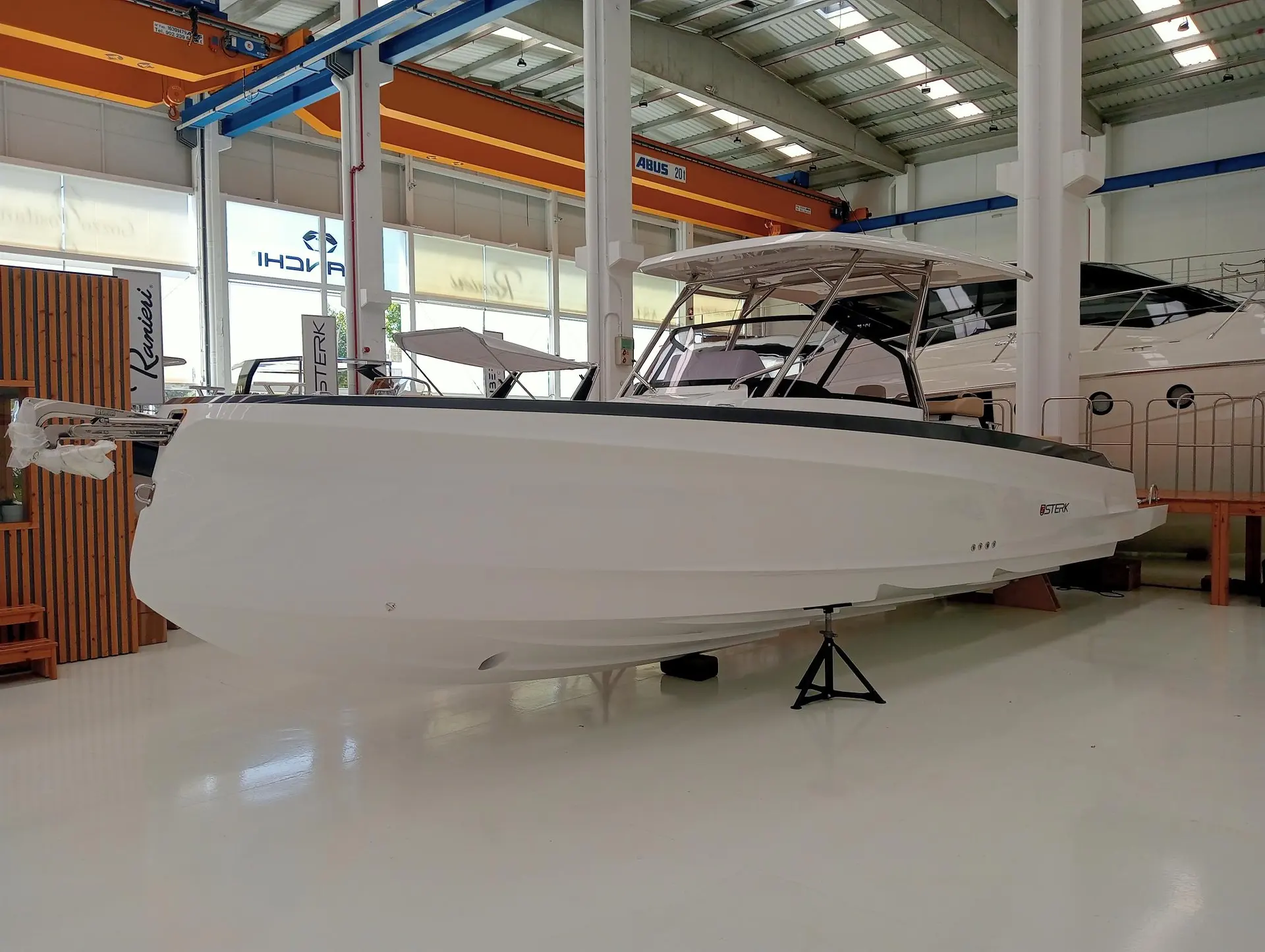 Sterk 31 WB Sport — Bateau blanc présenté sur ber dans un showroom, vu de profil tribord.