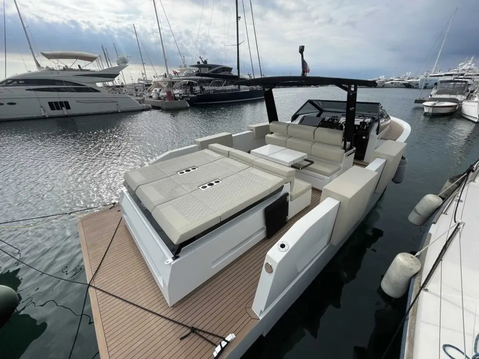 De Antonio Yachts D34 Cruiser — Bateau à moteur amarré, avec cockpit arrière, bain de soleil et poste de pilotage.