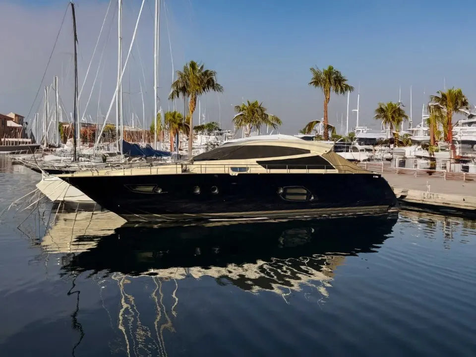 Cayman 57 HT — Bateau à moteur vu de profil dans une marina bordée de palmiers.