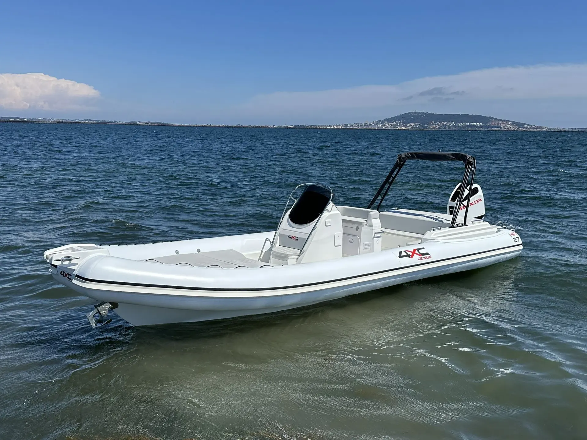 4XC HA27 — Semi-rigide blanc photographié sur l’eau, avec console centrale et arceau noir.